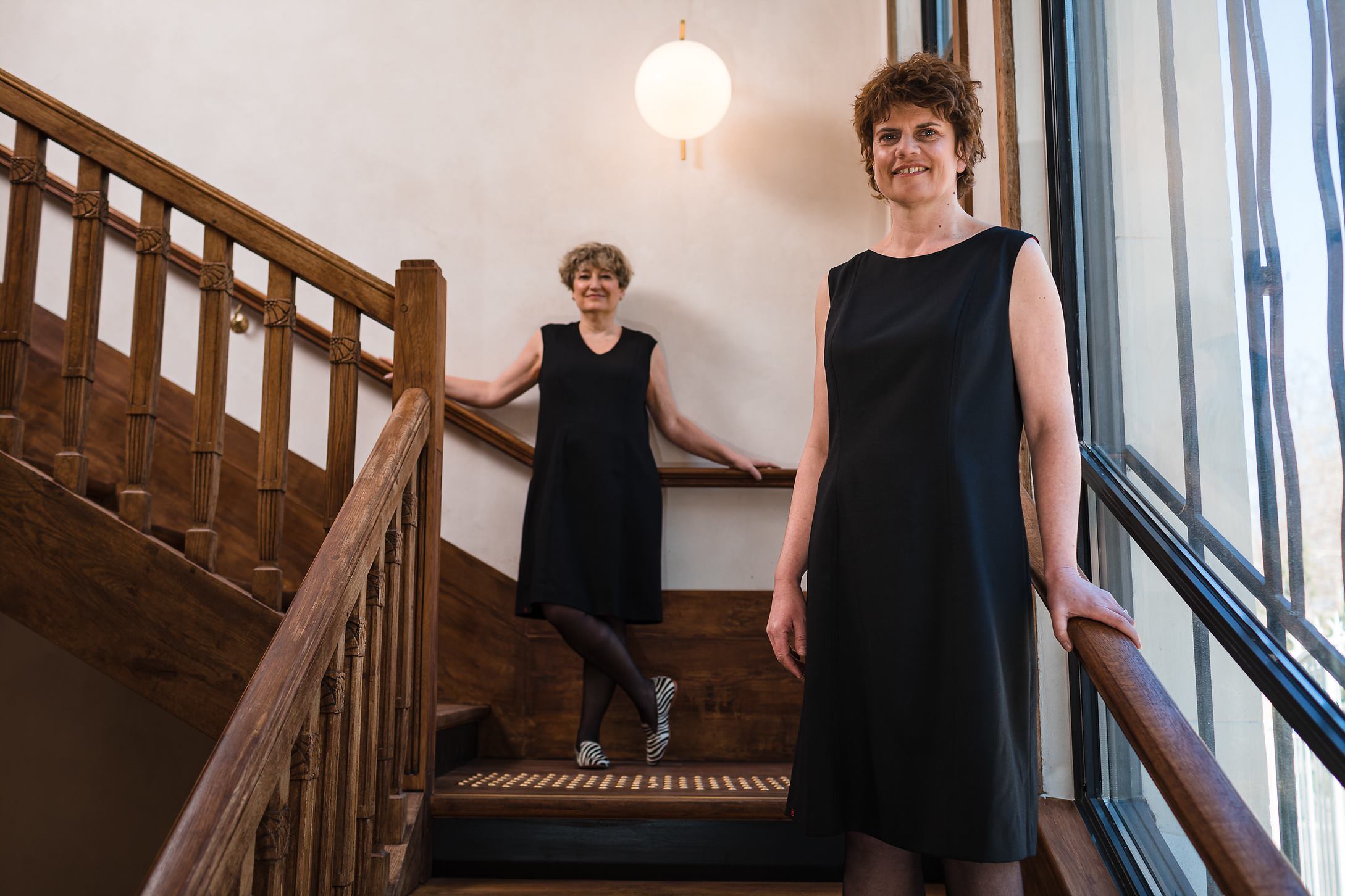 Deux modèles posant dans un escalier en robe chic et casual Laurence Glorieux.