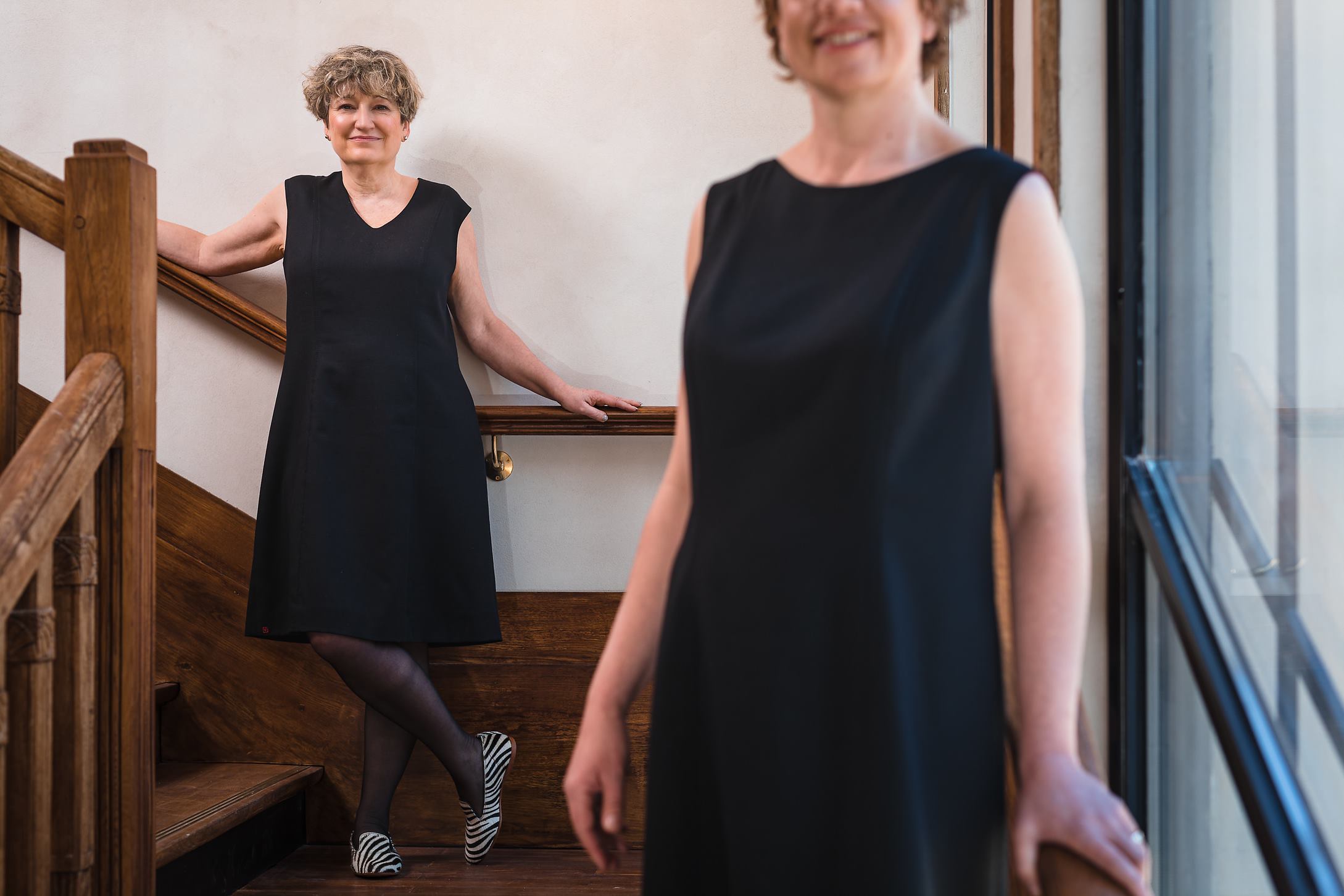 Deux modèles posant dans un escalier en robe sur-mesure et unique Laurence Glorieux.
