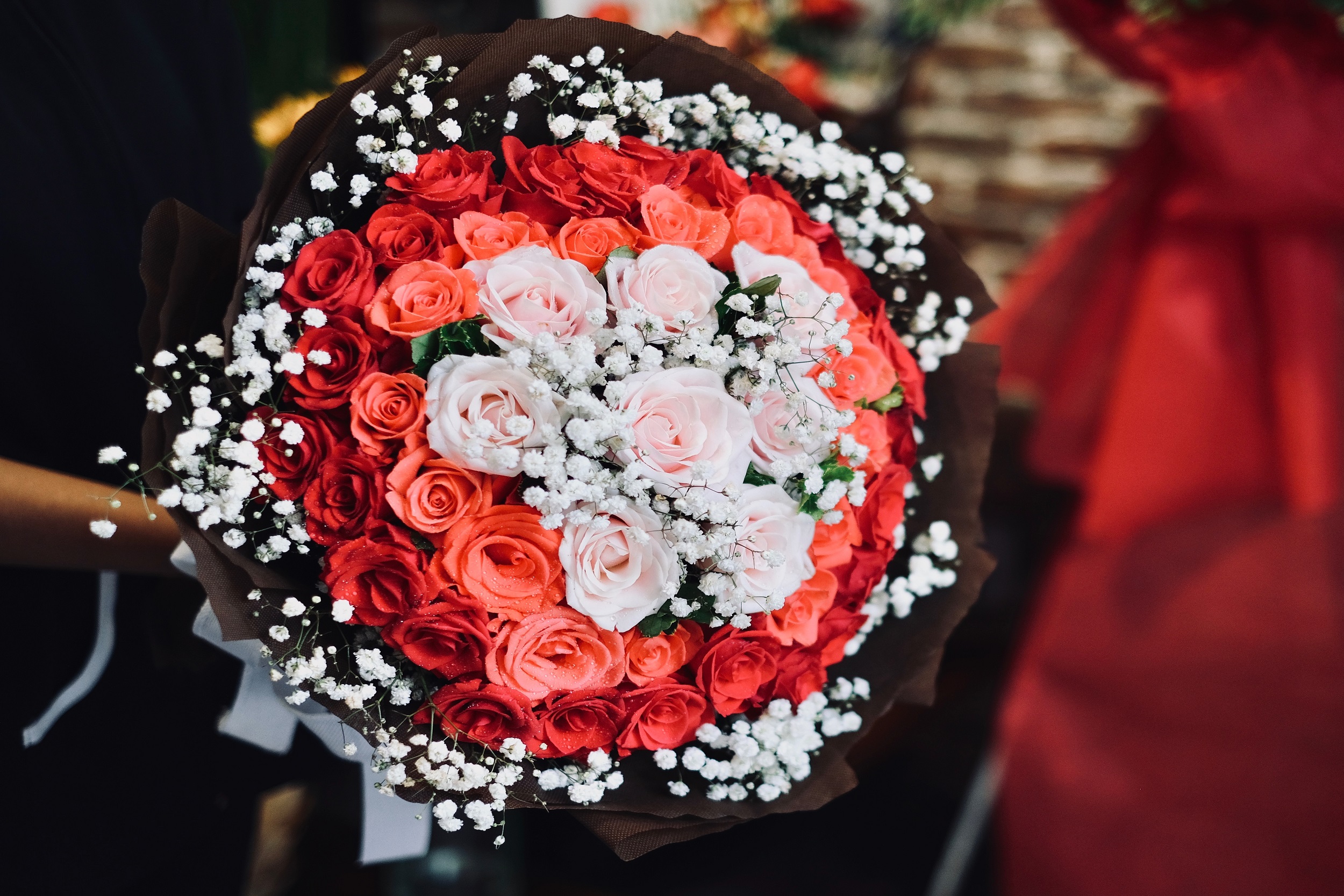 Bouquet de fleurs avec de roses rouges pour offrir à une femme. Laurence Glorieux.